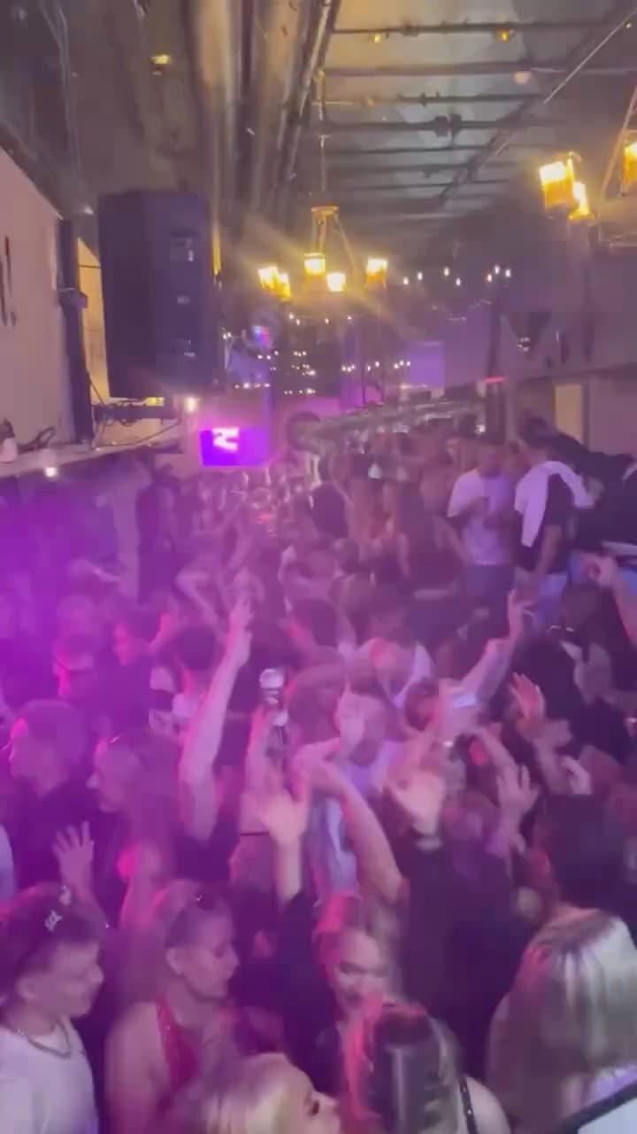 Täysi sali Rymy-Eetu Tampereella: yleisö tanssii kädet ilmassa violetissa valossa kattokruunujen alla